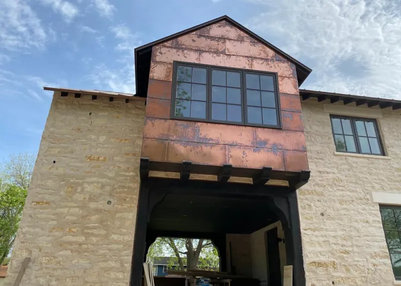 Copper metal panel facade on a stone building for Skylight Installation in Breckenridge